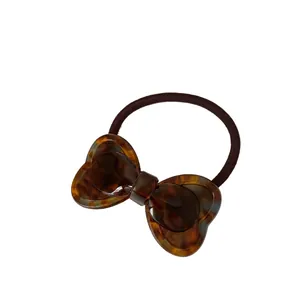 Elastic bow hair tie featuring a tortoiseshell pattern finish and durable brown band