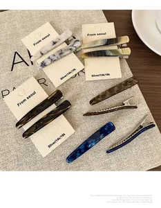 Détails de barrettes en acétate aux motifs écaille et marbre sur carte de support