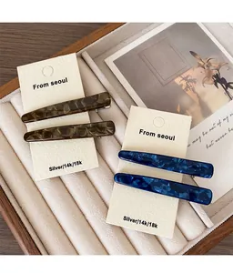 Détail de barrettes à cheveux rétro en acétate avec motifs écailles et marbre bleu