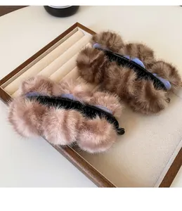 Detailopname van pluchen haarklemmen met faux fur ballen in bruin en roze op een tray