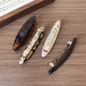 Set of four tortoiseshell and marble acetate hair clips with gold spring fasteners
