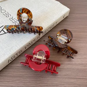 Three-piece acetate claw clip set in red, amber, and tortoiseshell for elegant hair styling