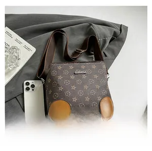 Vista detallada del bolso saco marrón con estampado de monograma y correa ajustable