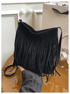 Close-up of black fringe shoulder bag with velvet texture and long tassels