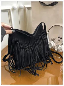Detail of black suede shoulder bag featuring long fringe tassels and metallic hardware