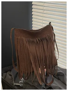 Detailed view of the dark brown suede texture and long fringe tassels on the shoulder bag