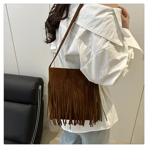 Détail d'un sac bandoulière en daim marron avec de longues franges bohèmes