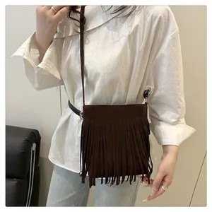 Détail d'un sac en daim marron foncé avec longues franges et boucles argentées