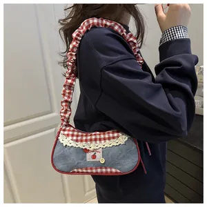 Dettaglio della borsa a spalla in denim con bordo a quadri rossi e pizzo fine