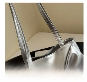 Detailed close-up of double stitching and metallic silver PU leather on a tote bag