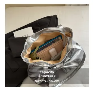 Detailed view of silver bow tote bag capacity showing tablet, notebook, and umbrella