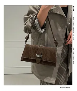 Détail du sac à bandoulière marron foncé effet froissé avec boucle argentée et nœud