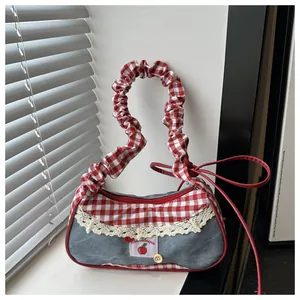 Dettaglio della borsa tote con motivo a quadretti rossi, denim e pizzo decorativo