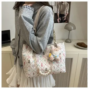 Détail du cabas à fleurs avec chaîne en perles, maillons dorés et breloque lapin rose