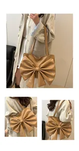 Close-up of a tan tote bag featuring a large bow design and durable shoulder straps