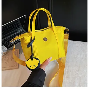 Détail du sac bandoulière en nylon jaune avec pendentif panda et sangle ajustable