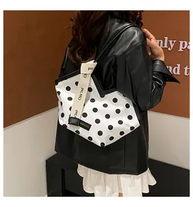 Gros plan d'un sac cabas à pois tendance avec une large bandoulière en tissu logotypée