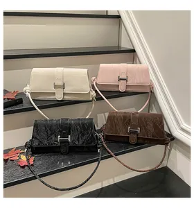 Détail de quatre sacs portés épaule rétro en cuir plissé sur des escaliers noirs