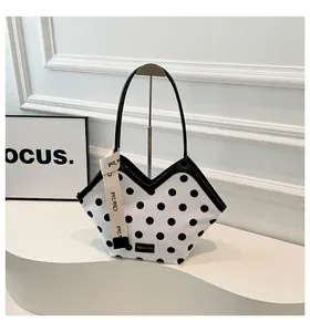 Vue détaillée du sac cabas à pois avec bordure en V et bandoulières fines en cuir