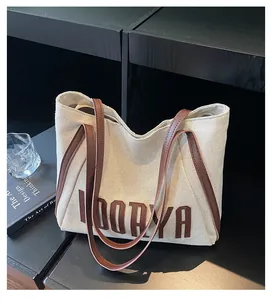 Gros plan du sac en toile montrant les lettres LOORYA 3D et les anses en cuir brun