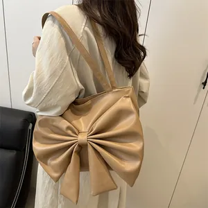 Chic camel faux leather tote bag with oversized bow, shown on shoulder for daily commute