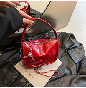 Close-up of red patent leather handbag with silver chain and Fashion embossed logo