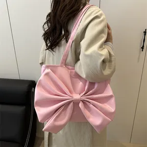 Pink oversized bow shoulder bag in premium PU leather for stylish summer fashion looks