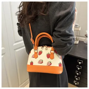 Détail du sac à main imprimé cerise avec garniture en cuir orange et double fermeture