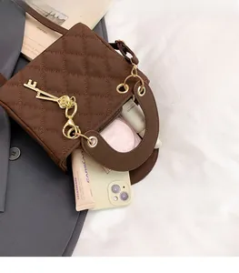 Detail of coffee brown quilted handbag showing interior storage for phone and cosmetics