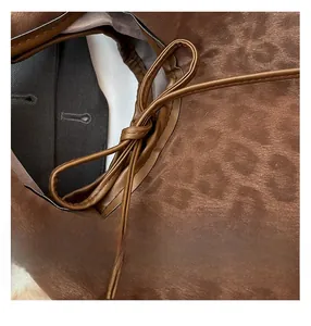 Detail of brown leopard print suede bag with knot design and fine craftsmanship