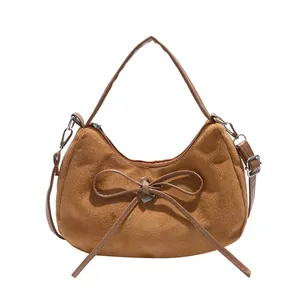 Brown suede hobo tote bag with heart pendant and adjustable strap on white background