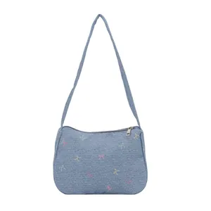 Minimalist light blue denim shoulder bag with colorful bow prints and silver zipper
