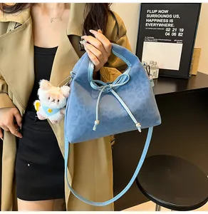 Blue leopard print crossbody bag with bow detail and plush bear charm on model
