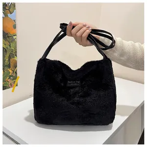 Detail of the black plush faux fur tote bag with leather straps and logo tag