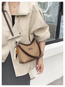 Nahaufnahme braune Canvas Umhängetasche mit Perlenanhänger an einem Model