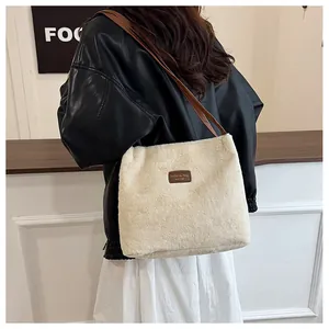 Detail of plush faux fur tote bag with brown leather straps and fashion label patch