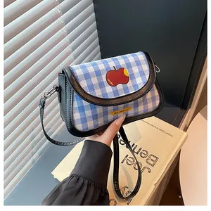 Detailed view of the blue checkered canvas saddle bag with apple pattern and strap