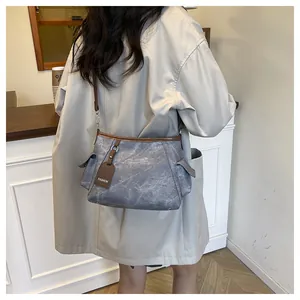 Detail view of the vintage bucket bag side pockets and brown leather edge stitching