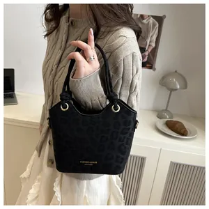 Détail du sac seau noir motif léopard avec logo doré et anneaux métalliques