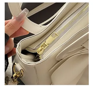 Detail van gouden metalen rits en stiksels op de witte mode bucket bag voor dames