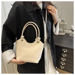 Détails de la poignée nouée et finition mate sur ce sac seau blanc crème chic