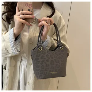 Détail du sac seau léopard gris en matière givrée avec des accents de logo doré élégant