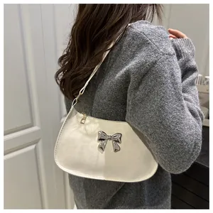 Vue détaillée du sac baguette blanc jacquard léopard avec décoration papillon en argent