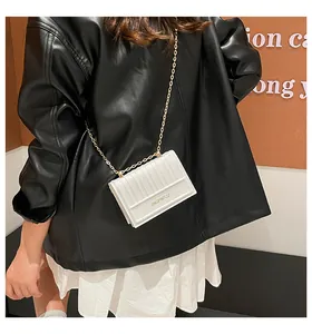 Vista dettagliata di una borsa a tracolla trapuntata bianca con catena dorata su modella