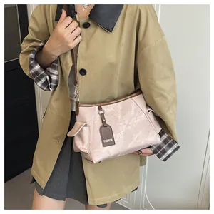 Detail of crossbody bucket bag with marble texture, side pocket and FASHION tag
