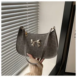 Détail du sac sous l'aisselle à imprimé léopard gris avec fermoir papillon argenté