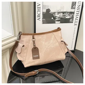 Detail of a beige canvas bucket bag with brown leather trim and fashion brand tag