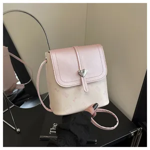 Detailed close-up of cute pink kitten print and heart buckle on cream bucket bag