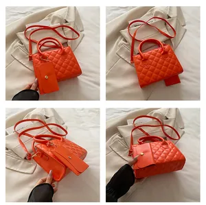Détail du sac à main matelassé orange vif avec mini pochette assortie et poignée