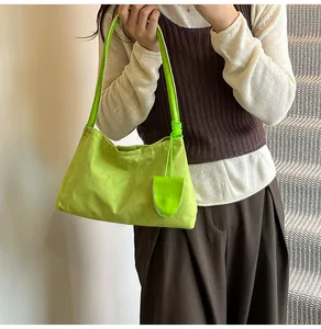 Detail view of the bright green fabric shoulder bag with matching round strap and pouch